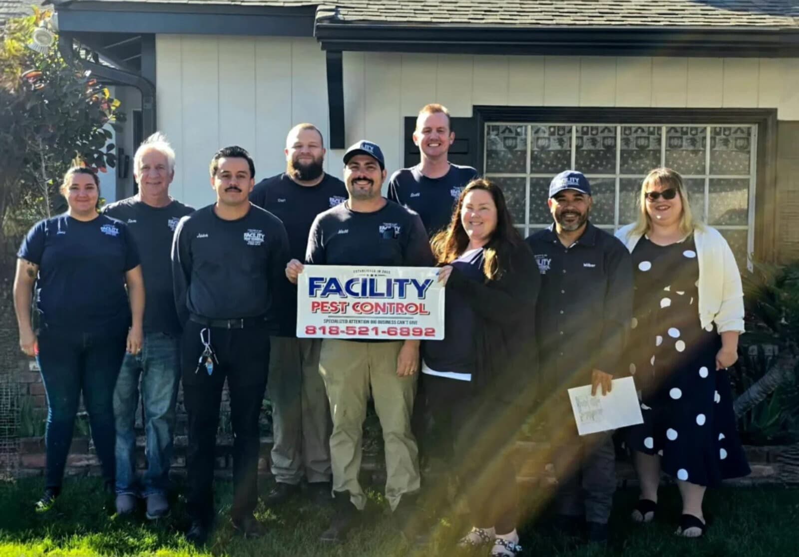 The Facility Pest Control team of nine in front of a Reseda home